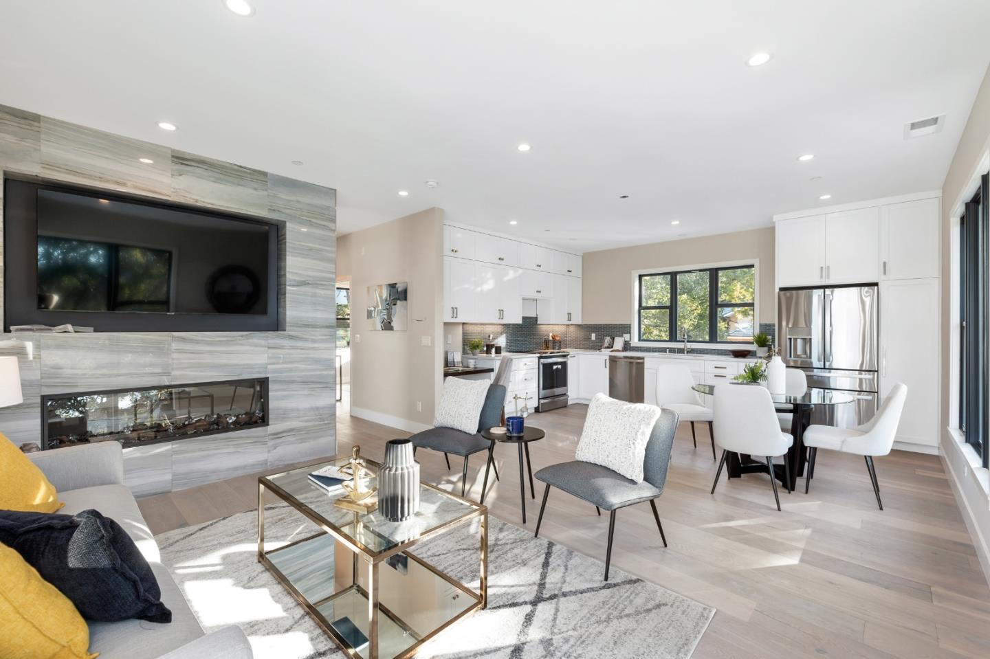 245 Eucalyptus Avenue Hillsborough, CA 94010 - Photo 22 of 27 a living room with furniture a fireplace and a flat screen tv