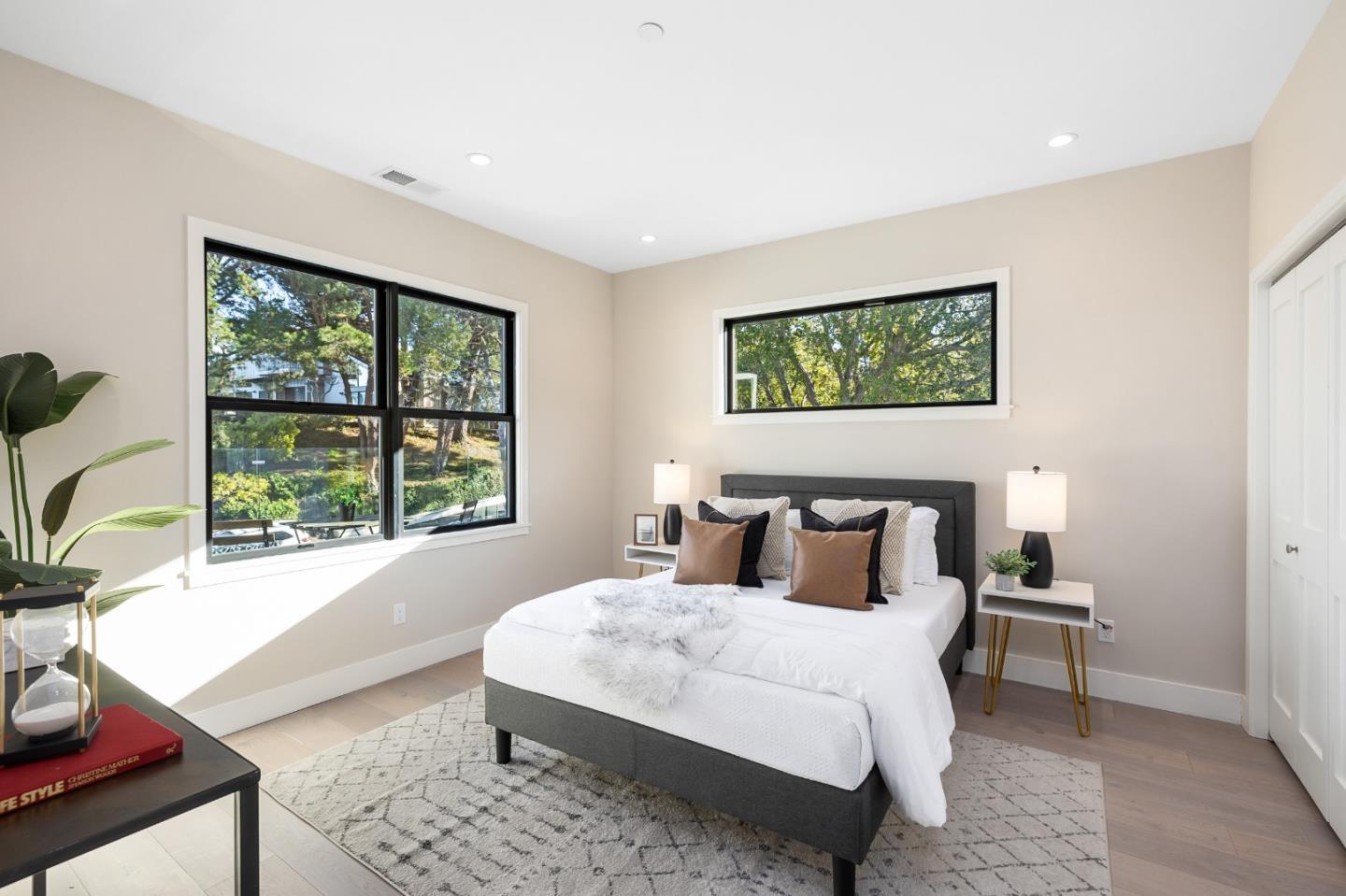 245 Eucalyptus Avenue Hillsborough, CA 94010 - Photo 24 of 27 a bedroom with a bed a mirror and a large window