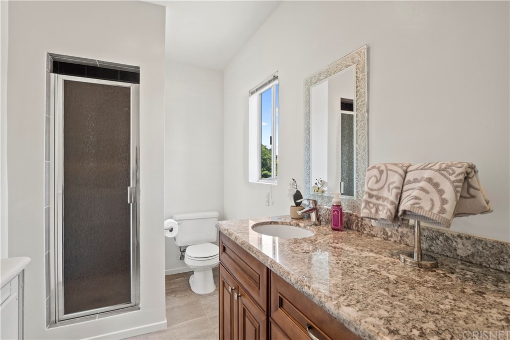 3653 El Caminito La Crescenta, CA 91214 - Photo 51 of 75 a bathroom with a granite countertop sink a toilet and a mirror