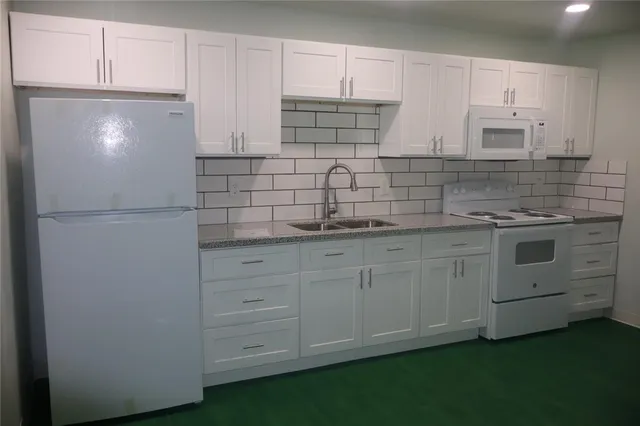 a kitchen with white cabinets and white appliances