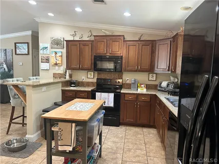 a kitchen with granite countertop a sink a counter top space stainless steel appliances and cabinets