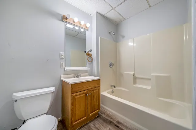 a bathroom with a toilet sink vanity tub and shower