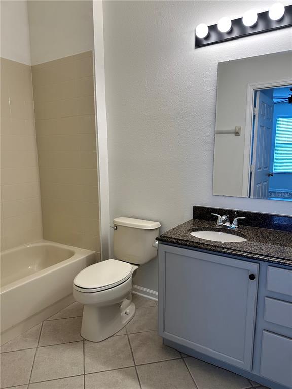 13584 Turtle Marsh Loop, Unit 132 Orlando, FL 32837 - Photo 15 of 21 a bathroom with a granite countertop toilet a sink and bathtub