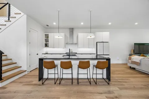 a large kitchen with granite countertop a large island in the center