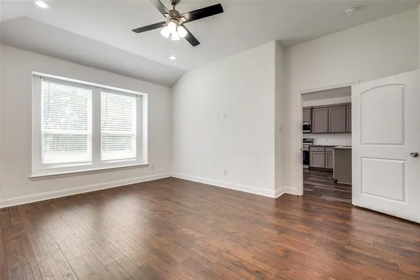 a view of empty room with wooden floor and window