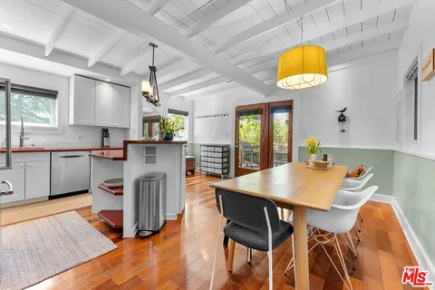 a kitchen with a table chairs and a wooden floor