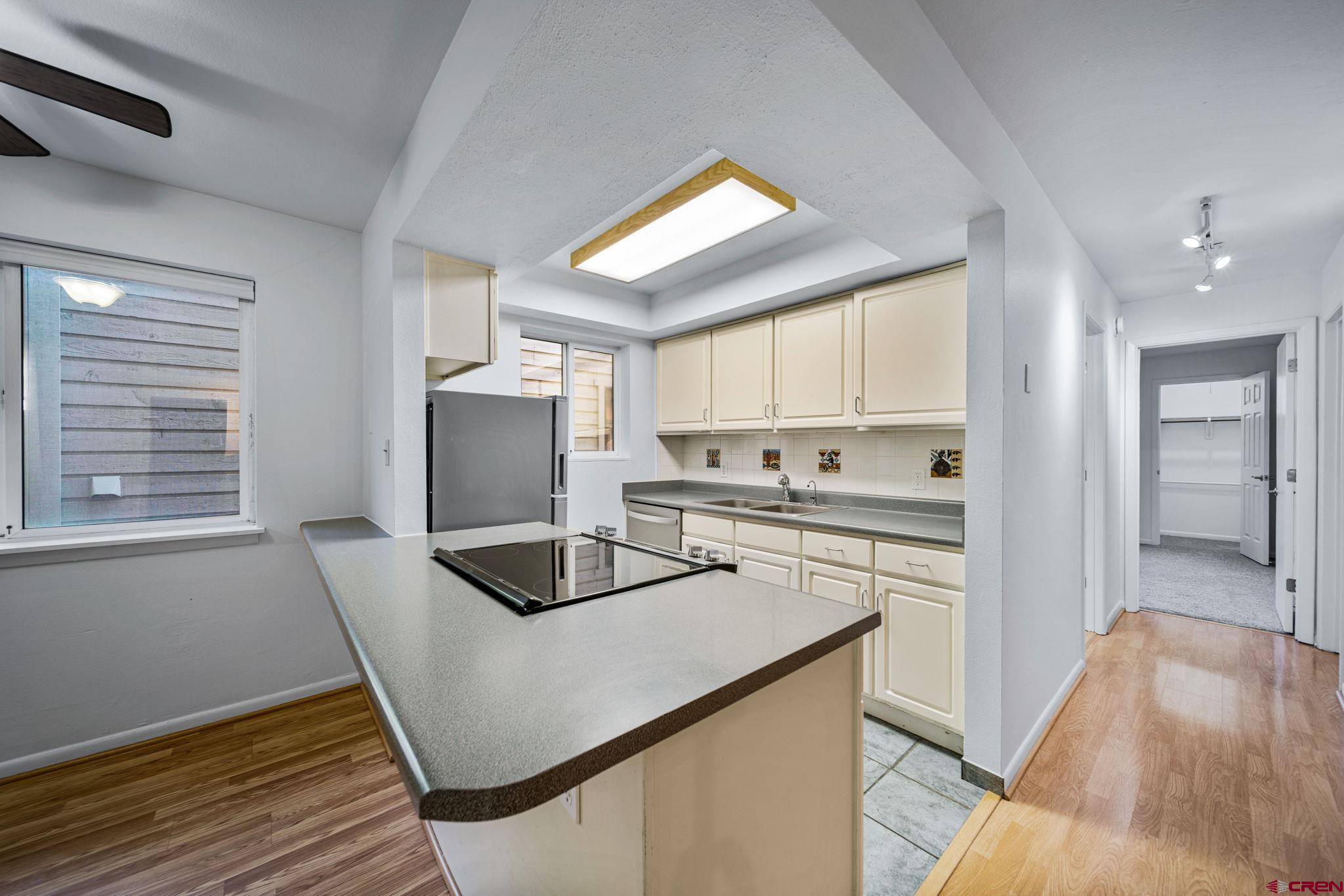 1200 Florida Road, Unit 11 Durango, CO 81301 - Photo 17 of 19 a kitchen with granite countertop white cabinets and white appliances
