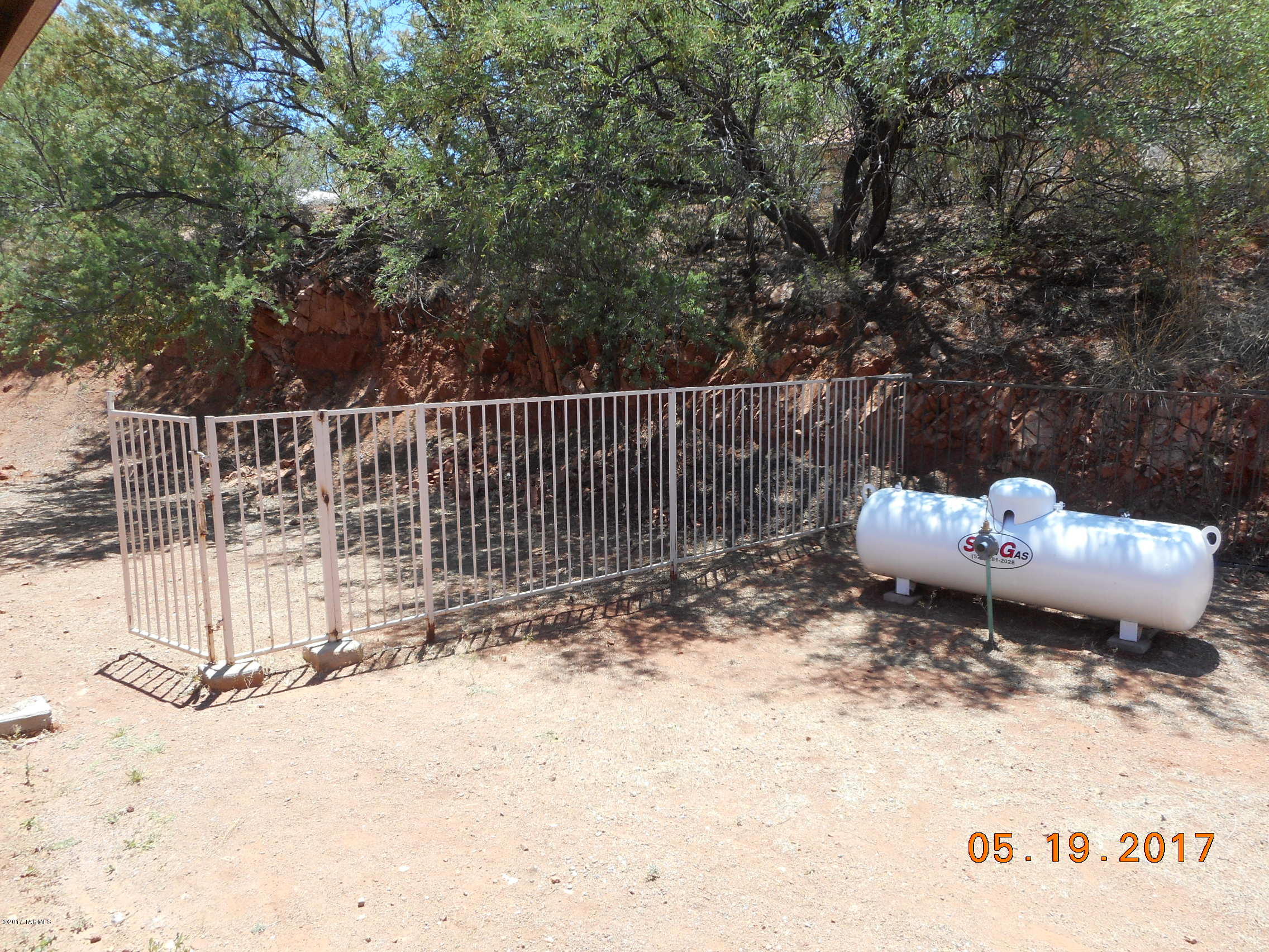 165 Entrada Court Rio Rico, AZ 85648 - Photo 33 of 33 a view of a backyard with a fire pit and wooden fence