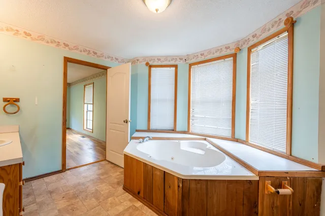 a bathroom with a granite countertop sink and a large mirror
