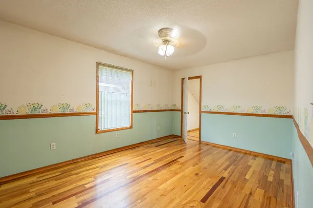 a view of a room with wooden floor and a ceiling fan