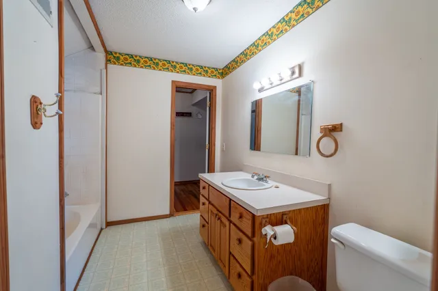 a bathroom with a sink a toilet a mirror and shower