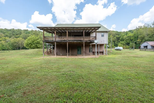 a view of a house with pool and a yard