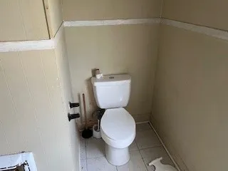 a white toilet sitting next to a shower