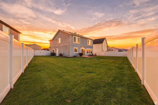 1566 Silver Canoe Loop Logan, UT 84321 - Photo 3 of 44 Expansive backyard featuring a manicured lawn, full perimeter fencing, and an exterior patio