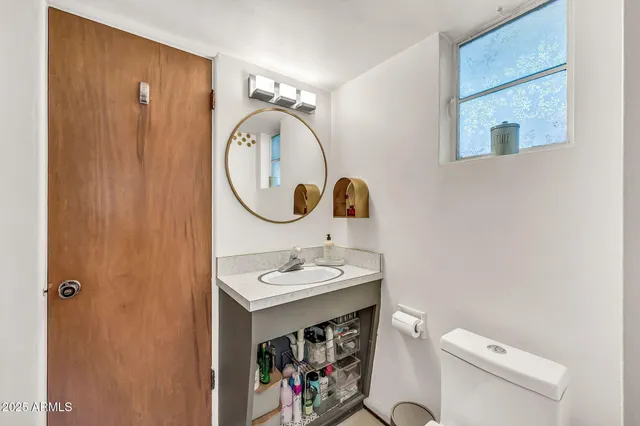 a bathroom with a sink a toilet and a mirror