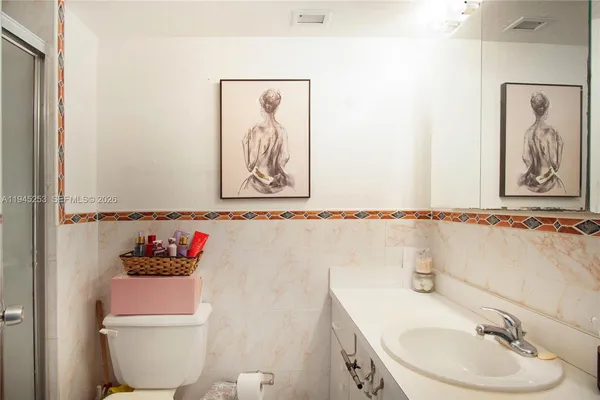 a bathroom with a sink mirror and toilet