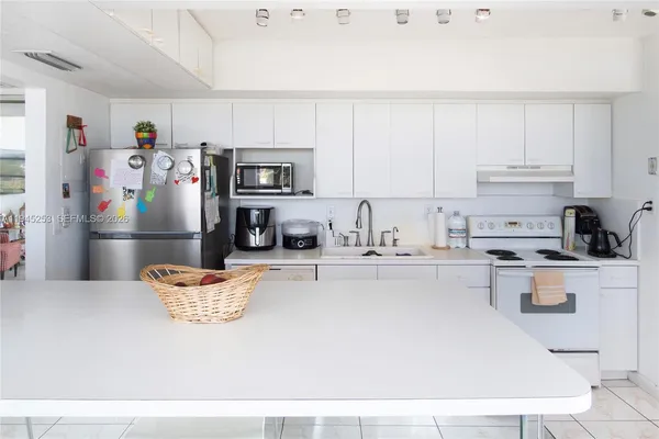 a kitchen with stainless steel appliances granite countertop a refrigerator sink and cabinets