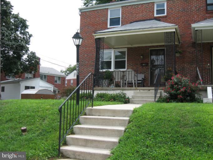 6900 Fieldcrest Road Baltimore, MD 21215 - Photo 1 of 15 a front view of a house with a garden and plants