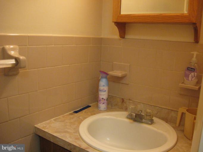 6900 Fieldcrest Road Baltimore, MD 21215 - Photo 2 of 15 a bathroom with a sink and a mirror