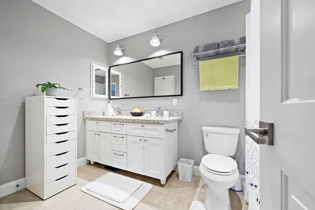 a bathroom with a sink a toilet and mirror