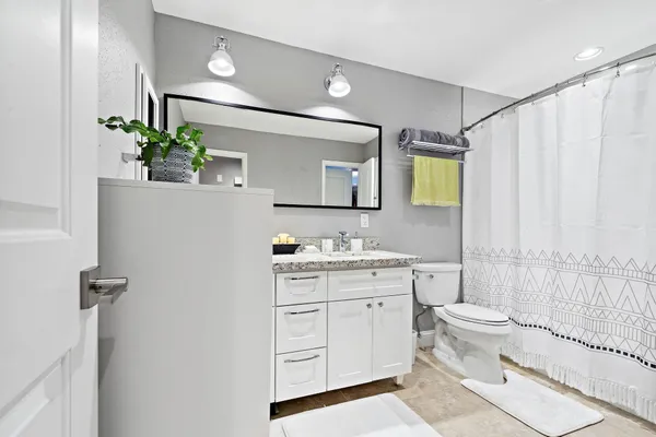 a bathroom with a double vanity sink toilet and shower