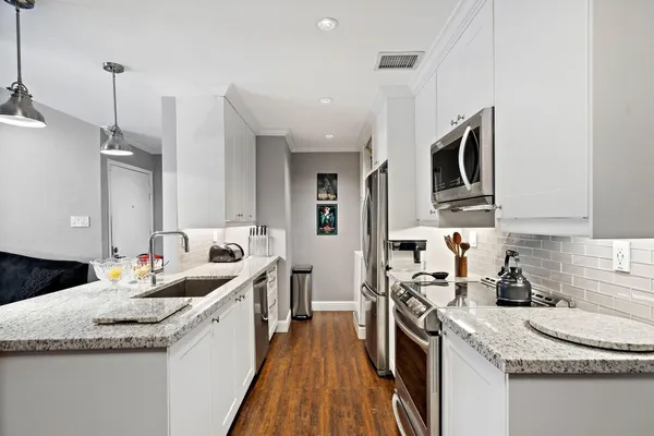 a kitchen with stainless steel appliances granite countertop a sink stove and refrigerator