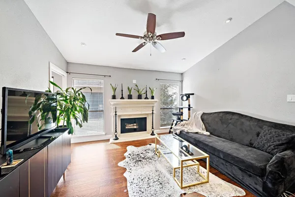 a living room with furniture a flat screen tv and a fireplace