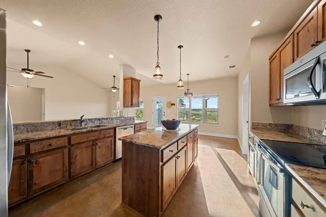 a kitchen with stainless steel appliances granite countertop a sink stove and refrigerator