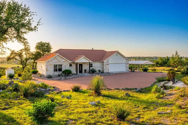 a front view of a house with a garden and yard