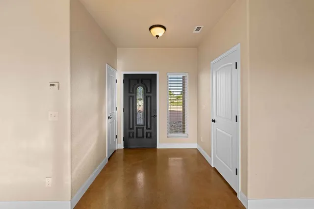 a living room with couch and a dining table with wooden floor