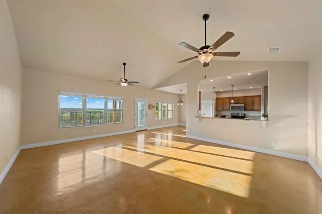 a view of a kitchen with kitchen island a sink stainless steel appliances and cabinets