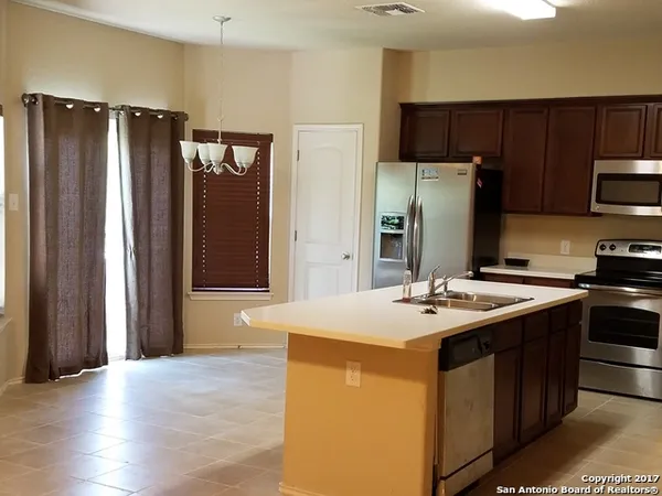 a kitchen with stainless steel appliances granite countertop a refrigerator and a stove top oven