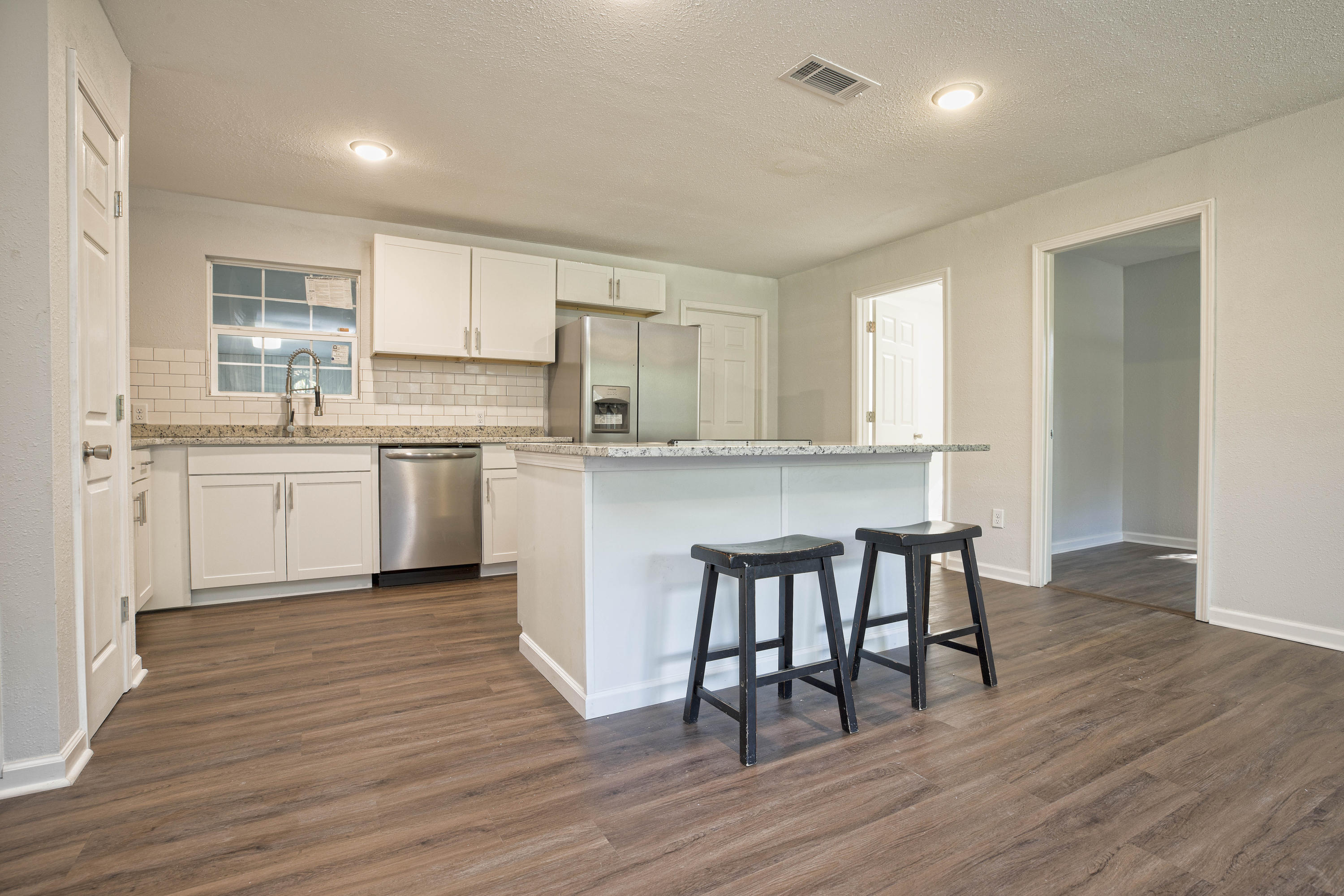 695 Ridge Lake Road Crestview, FL 32536 - Photo 12 of 27 a kitchen with kitchen island granite countertop wooden floors and white stainless steel appliances
