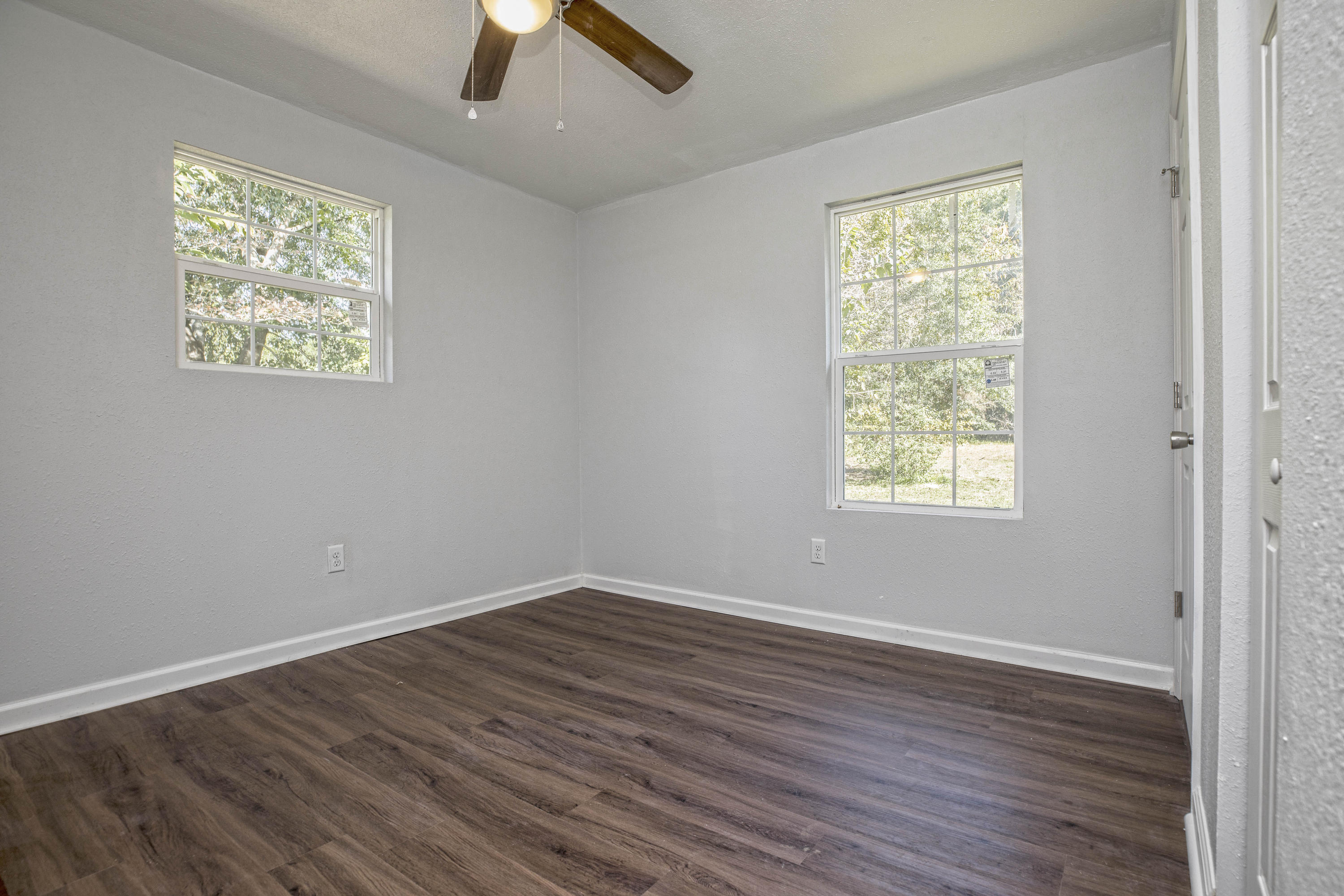 695 Ridge Lake Road Crestview, FL 32536 - Photo 25 of 27 an empty room with wooden floor and windows