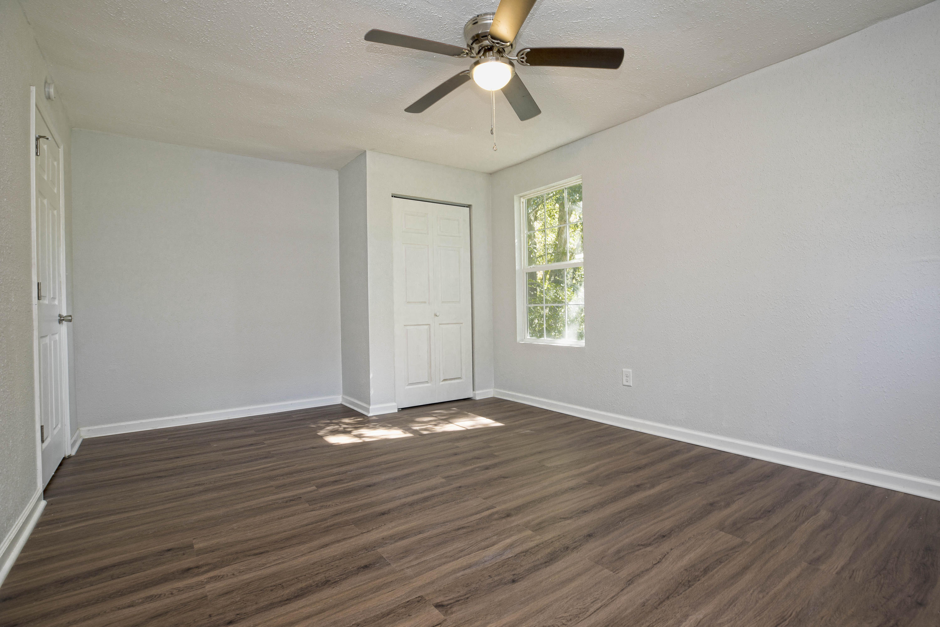 695 Ridge Lake Road Crestview, FL 32536 - Photo 27 of 27 an empty room with wooden floor ceiling fan and windows