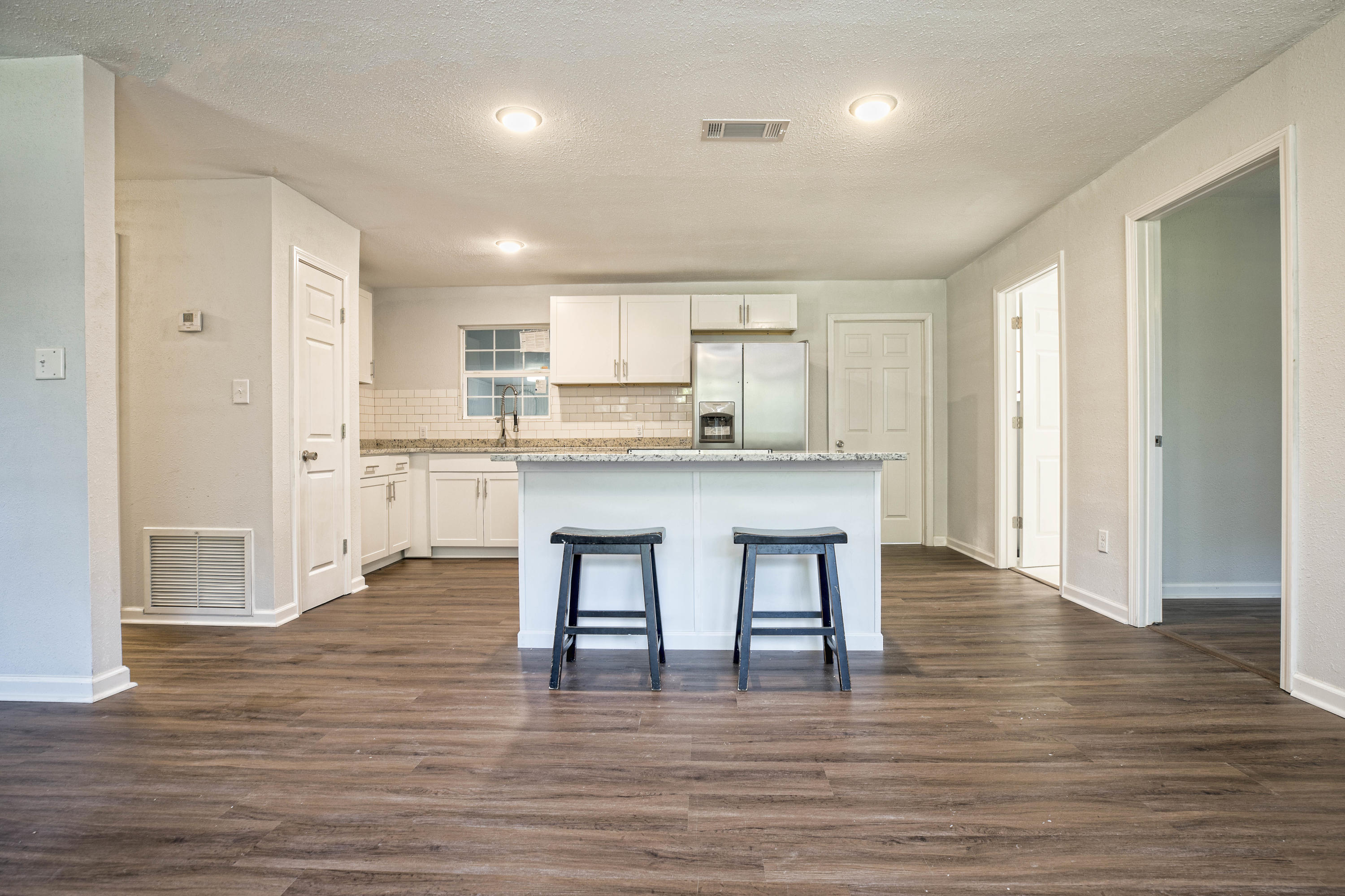 695 Ridge Lake Road Crestview, FL 32536 - Photo 3 of 27 a large kitchen with stainless steel appliances granite countertop a stove a sink dishwasher and a refrigerator with wooden floor