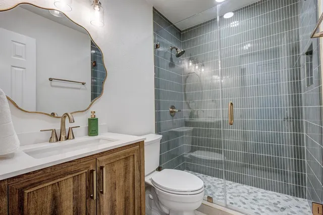 a bathroom with a sink a toilet and mirror