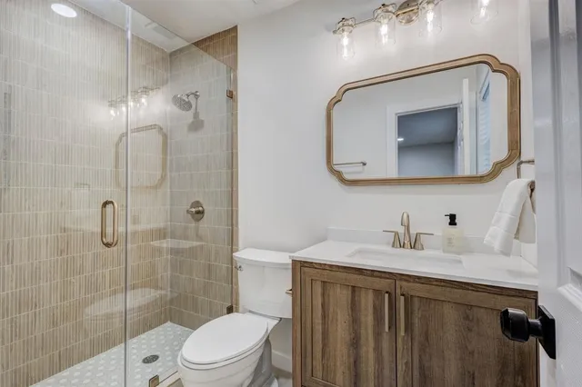 a bathroom with a sink a toilet and shower