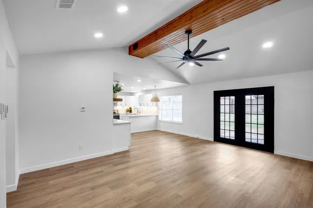 a view of a livingroom with a ceiling fan & wooden floor