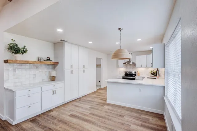 a kitchen with granite countertop a stove a sink and a refrigerator