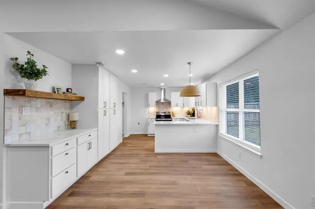 a kitchen with counter top space and wooden floor