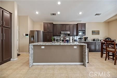 39366 11th Street West Palmdale, CA 93551 - Photo 8 of 15 a kitchen with stainless steel appliances granite countertop a refrigerator a stove a sink a dining table and chairs