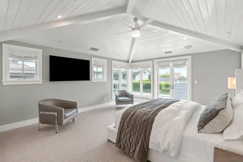 a spacious bedroom with a bed and a flat screen tv