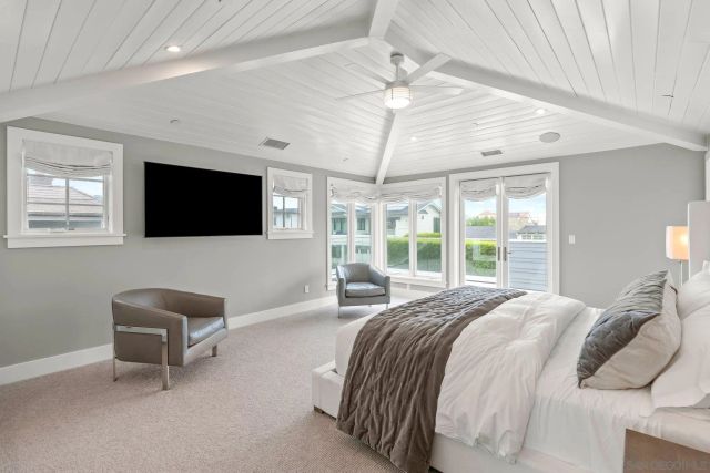 a spacious bedroom with a bed and a flat screen tv