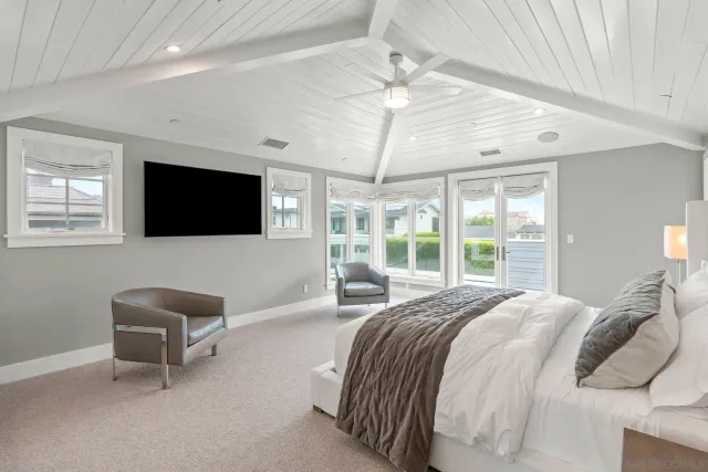 a spacious bedroom with a bed and a flat screen tv