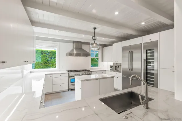 a kitchen with stainless steel appliances granite countertop a stove a sink and a refrigerator