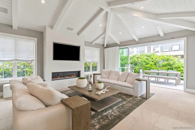 a living room with fireplace furniture large window and a flat screen tv