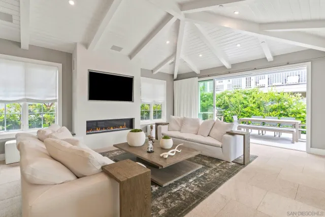 a living room with fireplace furniture large window and a flat screen tv