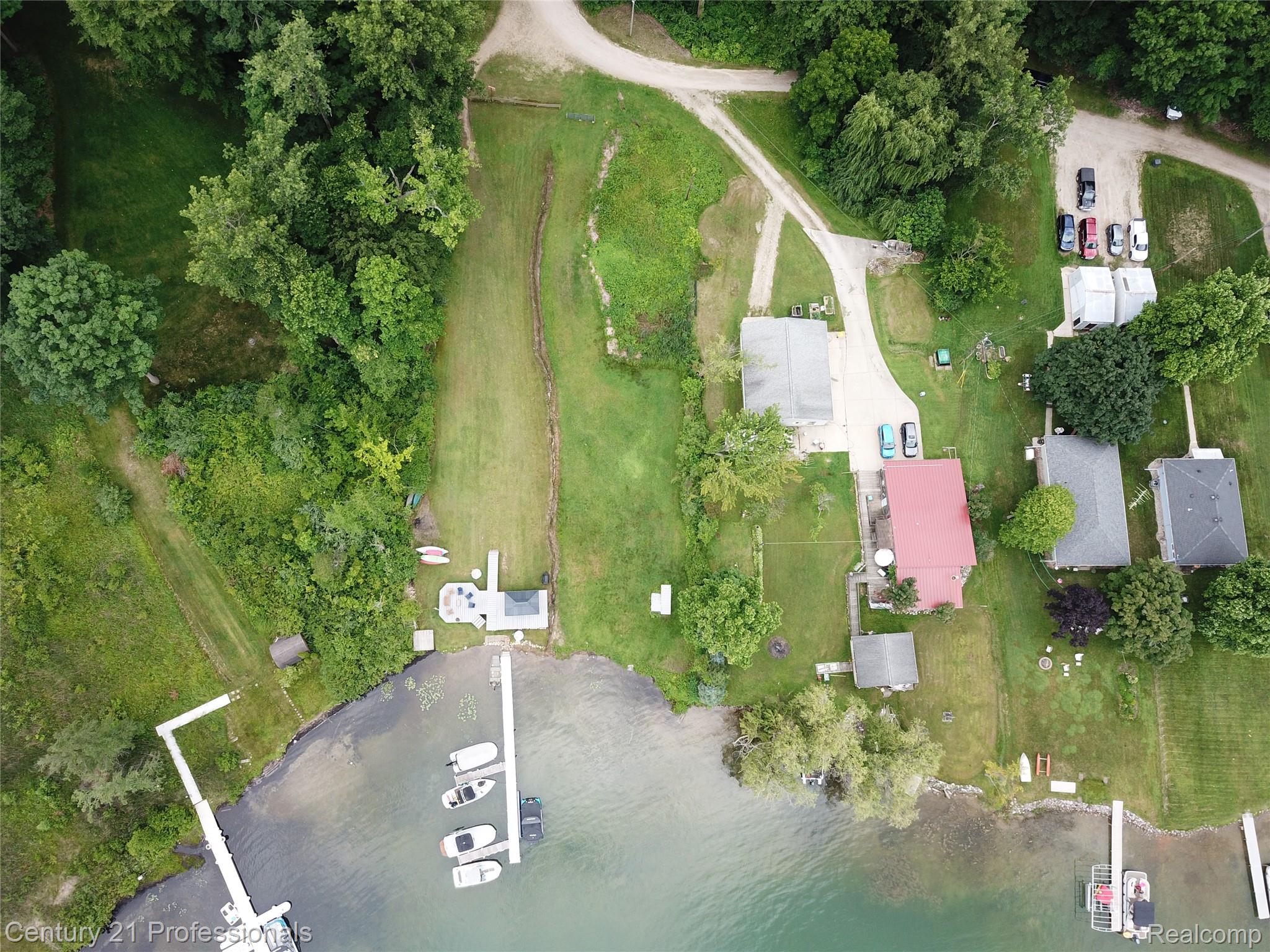 9867 Rainbow Ridge Drive Schoolcraft, MI 49087 - Photo 74 of 82 Waterfront property featuring a private dock with multiple boat slips, a shoreline structure, and expansive green spaces