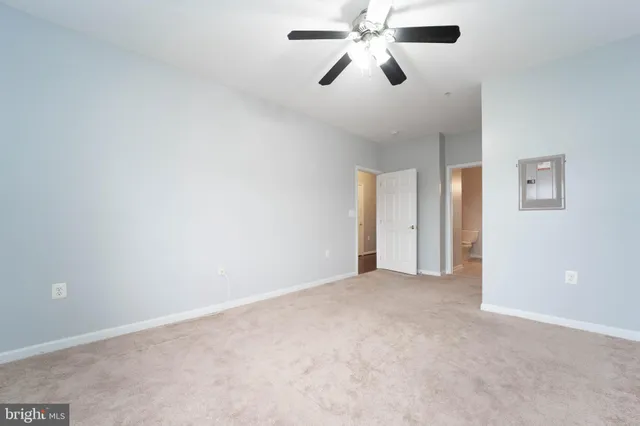 an empty room with chandelier fan